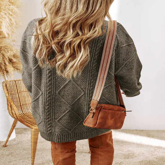 Person wearing a green cable knit sweater with a brown leather bag. - Fashlot