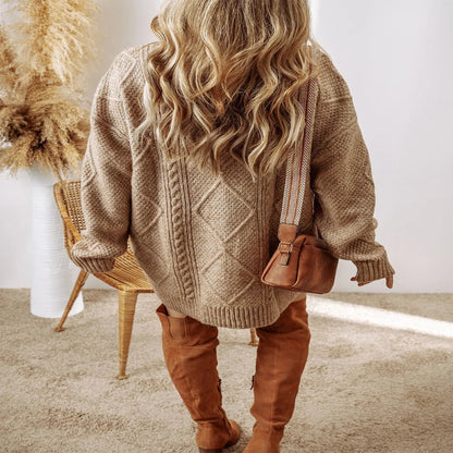 Lady wearing a beige sweater and brown pants with a brown bag indoors. - Fashlot