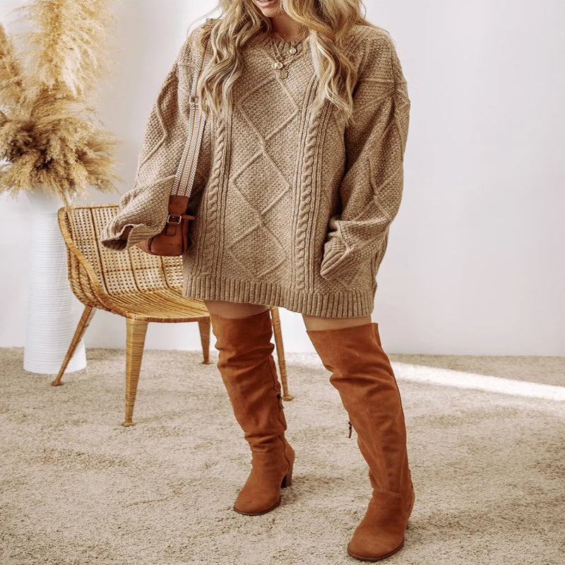 Woman wearing a beige cable knit sweater and brown knee-high boots in a cozy indoor setting. - Fashlot