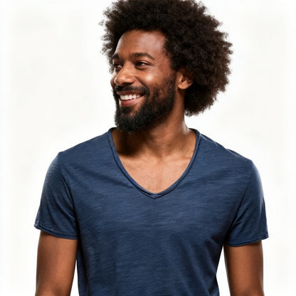 A smiling man with an afro hairstyle and beard wearing a heathered navy blue v-neck t-shirt, photographed against a clean white background. - Fashlot