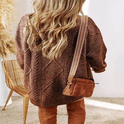 Person wearing a brown knitted cardigan and holding a brown bag indoors. - Fashlot