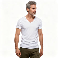 A man with gray hair and a beard wearing a plain white v-neck t-shirt and olive green pants, standing against a solid white background. - Fashlot