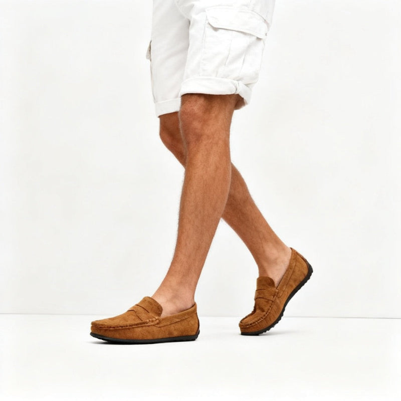 A person wearing tan suede penny loafers and white cargo shorts, shown from the waist down in a side-profile walking pose against a clean white studio background. - Fashlot