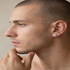Close-up side profile of a man wearing a small silver-toned flower-shaped stud earring in his earlobe. - Fashlot