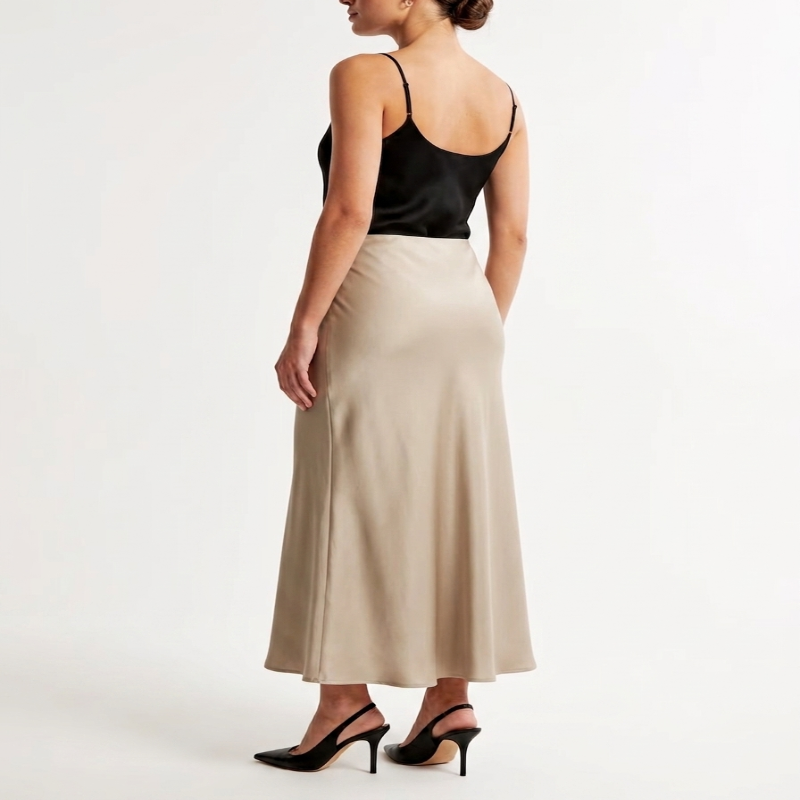 A woman shown from the back wearing a black satin spaghetti-strap camisole top and a high-waisted, floor-length beige satin skirt, paired with black high heels, against a plain white studio background. - Fashlot