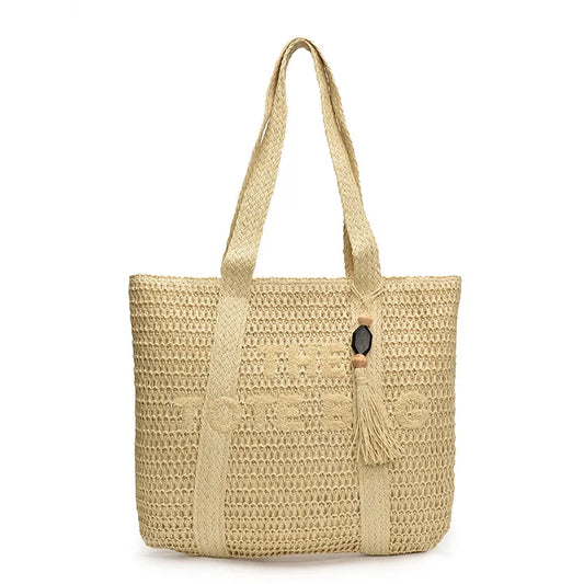 Beige woven crochet straw tote bag with wooden bead and tassel charm, standing on white background - Fashlot