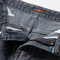 Close-up of a pair of blue jeans with a brand label on a white background
