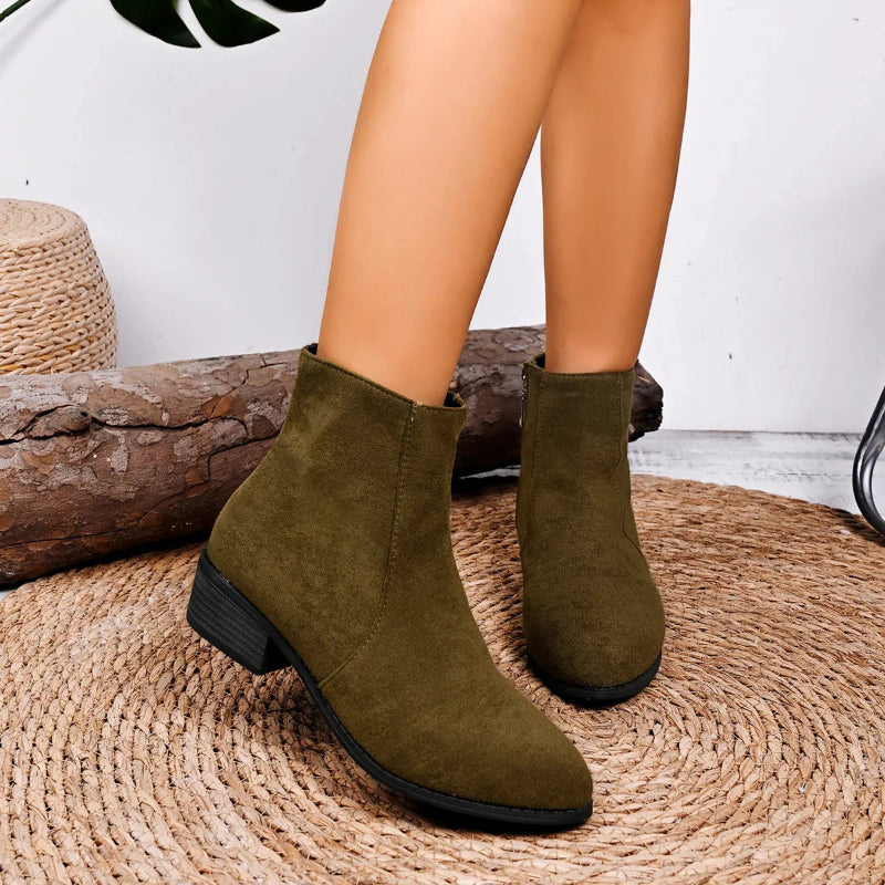 Green ankle boots worn by a person on a woven mat with a white wall background - Fashlot