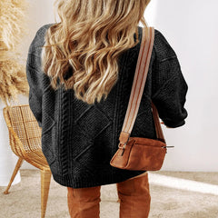 Person wearing a gray sweater and brown leather pants with a brown leather bag, standing indoors. - Fashlot