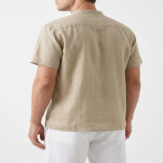 A man shown from the back wearing a light beige short-sleeve linen shirt and white pants, photographed against a clean white studio background. - Fashot